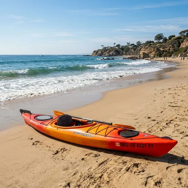 Brightly colored kayak resting on a sandy beach in Southern California, with the ocean in the background
